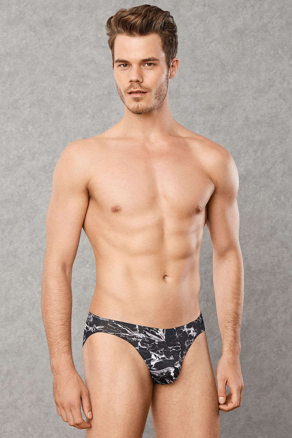 Beautiful marble print men's brief underwear. A male micro bikini slip dressed in white and grey on black. No waistband. Buy online now