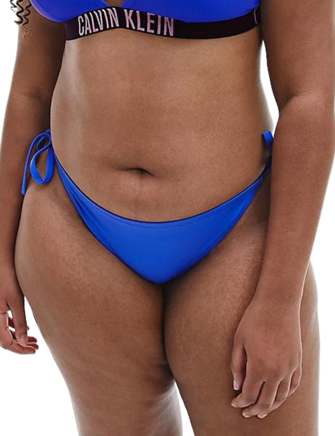 Create a bold beach look this summer with the Calvin Klein Intense Power range. It introduces this plus size bikini bottom that is a must-have. This bikini brief is made from smooth microfibre to create a comfortable fit whilst the tie-side detail is adjustable allowing for an individual fit. It has a mid-rise waist and provides medium rear coverage. Finished off with the iconic Calvin Klein logo across the upper rear.  Plus size bikini brief Tie sides Smooth microfibre Mid-rise waist Medium rear coverage Iconic Calvin Klein logo at the rear Country of Origin:- Vietnam Composition:- 78% Recycled Polyamide &pipe; 22% Elastane Listed in UK sizes  55329-98672-1280508 KW0KW01863 Bikini Bottoms