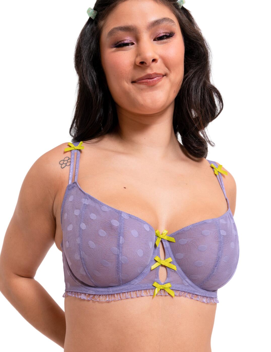 Turn heads in this flirty balcony bra from the Frill Me range by Curvy Kate! This stylish and playful bra is embellished with polka dot tulle and contrasting bows that create a striking look. This bra uses recycled materials so you can achieve a fabulous look while being eco-conscious! Split strap details and frill trimming adorn the underband, finishing the bra to stylish, feminine perfection. Underwired cups and a classic balcony design offer total comfort and support, designed with plus size cups in mind. The bra is unpadded, for a comfortable and more natural appearance. Complete the look with the matching thong from the Frill Me range.