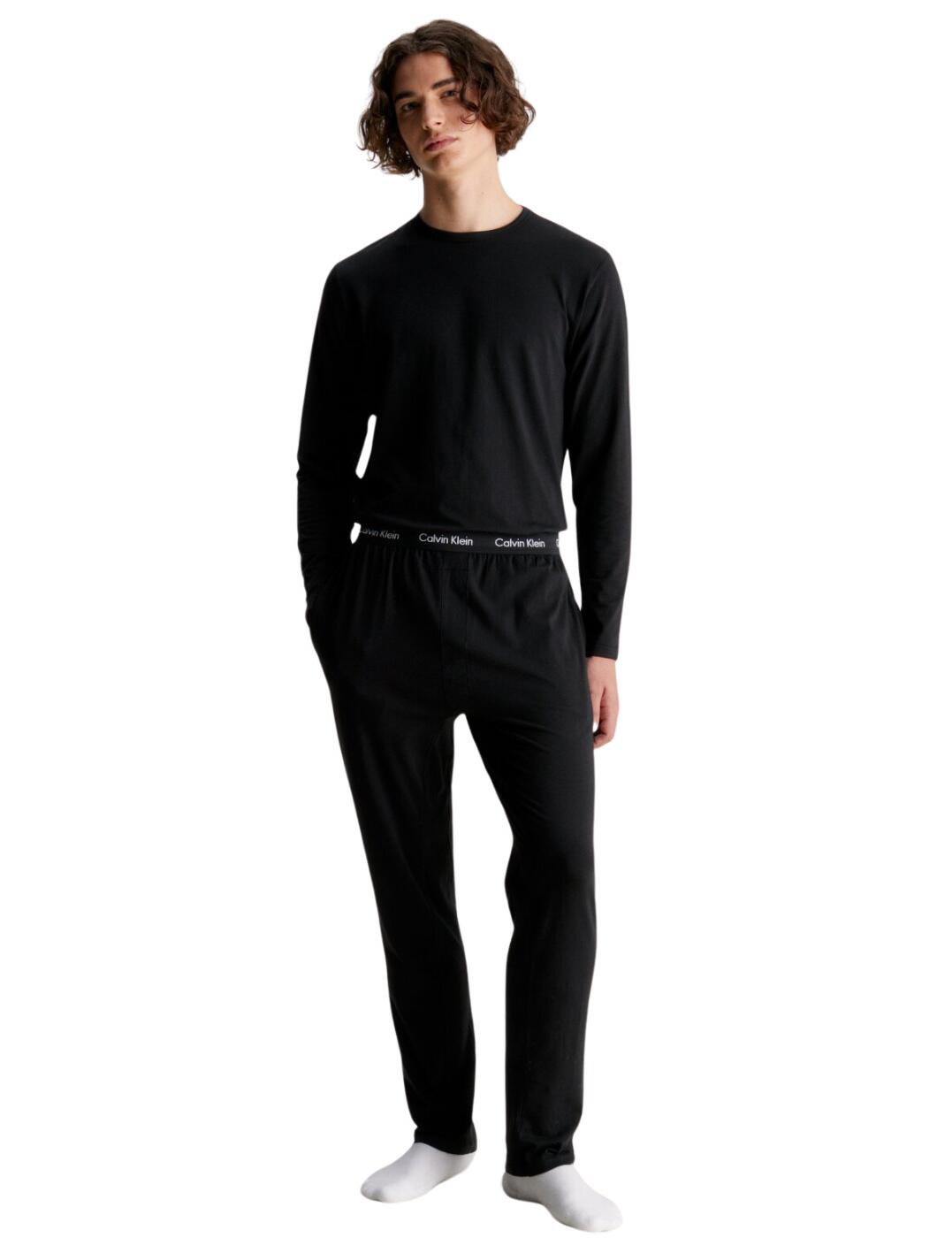Get ready for a night of restful sleep with the Calvin Klein Men's Cotton Stretch pyjama set. Perfect for comfortable, everyday wear, each set comes with a long-sleeved top with a crew neckline, and soft, regular-fit pants. They have an easy pull-on style with a branded elastic waistband and iconic branding throughout for an unmistakably stylish look. Enjoy ultimate relaxation in these comfy pyjamas any night of the week – the ideal choice for men who value comfort as much as style.  Comfy pyjama set Long sleeve top Crew neckline Soft fit Regular fit pants Easy pull-on style Branded elasticated waistband Iconic branding throughout Country of origin: Bangladesh Composition: 95% Cotton &pipe; 5% Elastane Listed in UK sizes  62912-108344-1437423 000NM2510E Men's Pyjamas