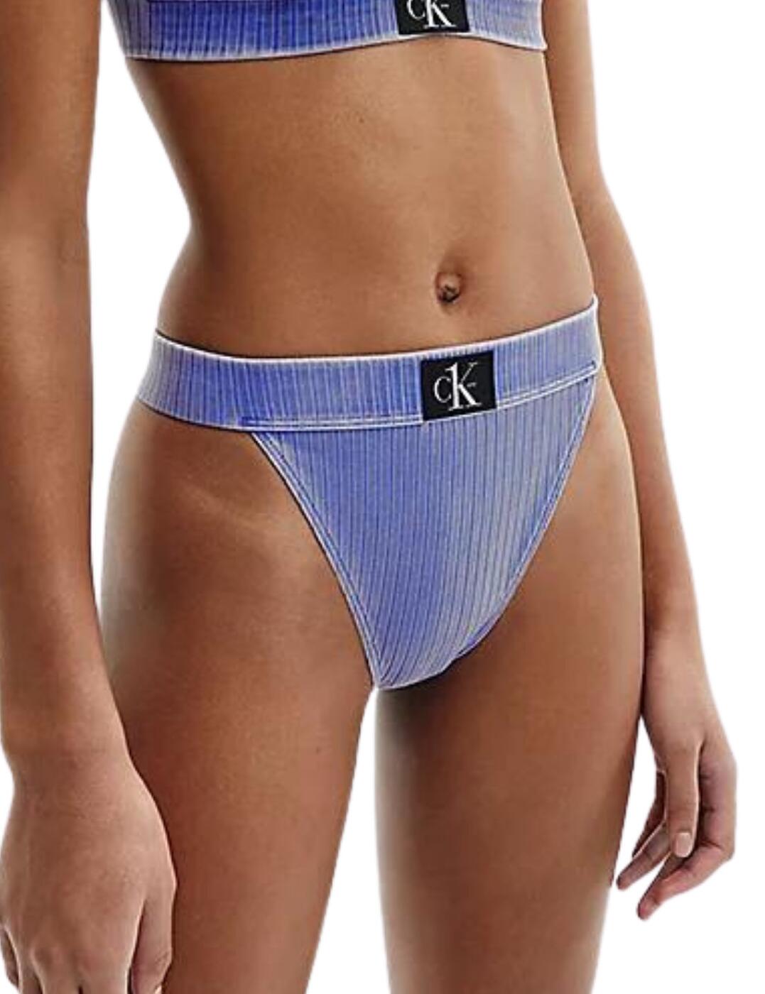 Time for a truly unique twist on the classic swimwear outfits, and Calvin Klein comes up with this gorgeous CK Authentic collection. These bikini briefs show all the usual cheeky sides of a moderate rear coverage, high-waisted design with high side cuts, which beautifully lengthen your legs. The individuality of this range comes with the Calvin Klein Jeans' heritage-inspired washed denim look. The ribbed knit material gives additional depth to this amazing piece, with the iconic CK badge front and centre for a trendy look.  Ribbed knit washed denim material CK badge on the centre front High leg cuts High-rise waist Moderate rear coverage Matching coordinates available Country of origin: Sri Lanka Composition: 91% Recycled Nylon/Polyamide &pipe; 9% Elastane Listed in UK sizes  55204-98354 KW0KW01718 High Waisted Bikini Briefs