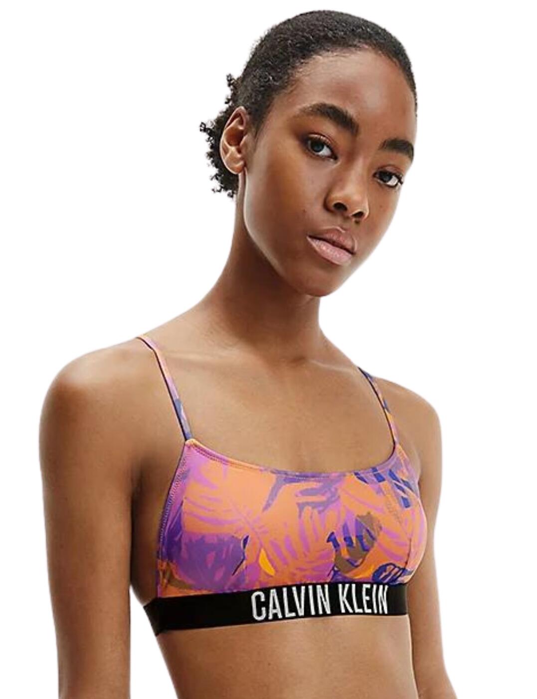 Refresh your swimwear collection this summer with the Intense Power range by Calvin Klein. This bralette bikini top features an all-over smooth microfibre in a fun print that has matte and glossy variations. It has the classic bralette style that has moulded cups where the padding can be removed to suit your preference. The bralette is an easy pull-on style for fuss-free wear and has slim adjustable straps allowing you to create the perfect fit. Made complete a Calvin Klein elastic under band.  Bralette bikini top Moulded cups with removable padding Smooth microfibre All-over fun print with matte and glossy variations Easy pull-on style Thin adjustable straps Clavin Klein elastic under band Country of origin: China Composition: 78% Recycled Polyamide &pipe; 22% Elastane Listed in UK sizes  56489-100255-1300986 KW0KW01831  Full Cup Bikini Top