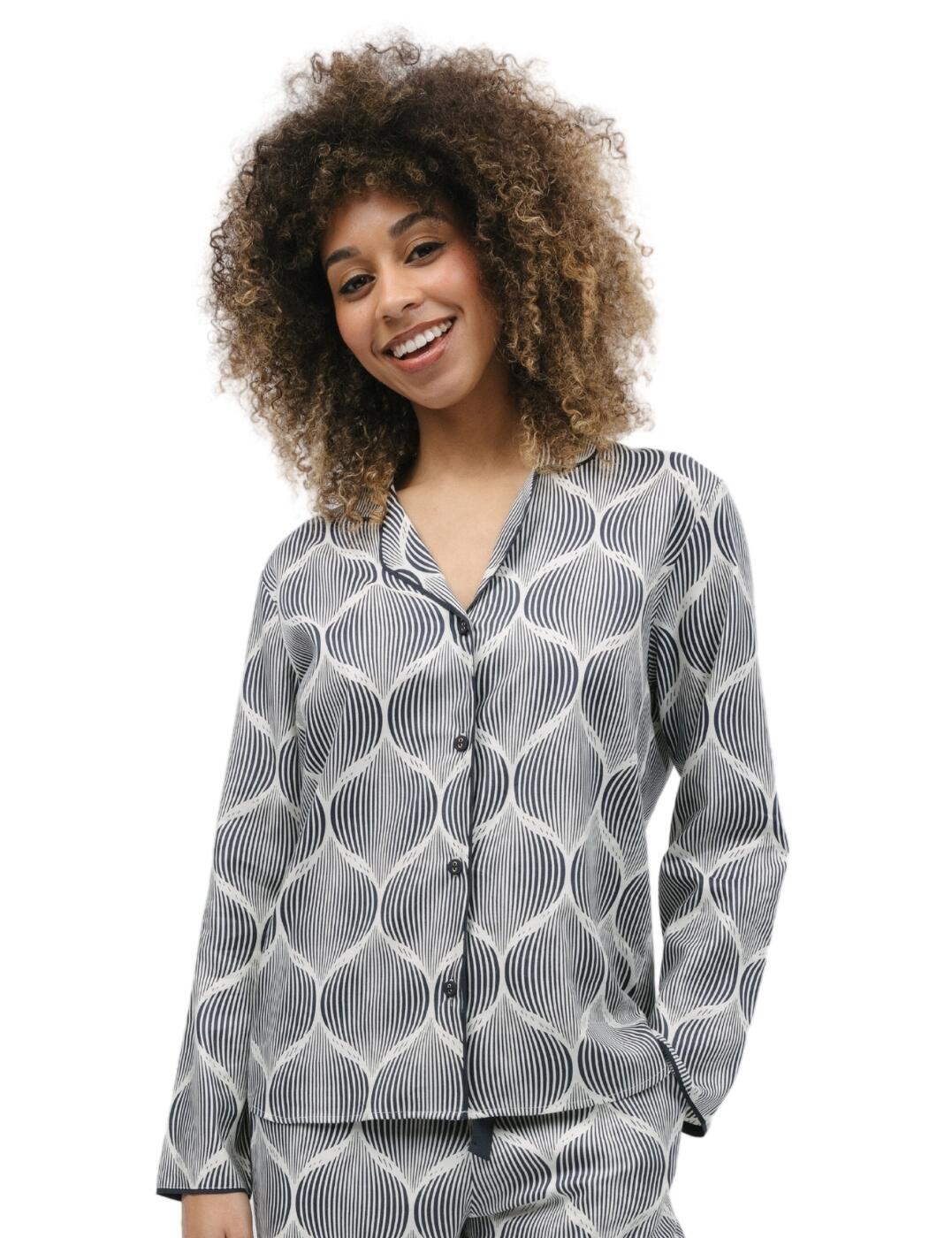 Pamper yourself with the glamourous Cyberjammies Nicole pyjama top! This trendy top has a unique geo print and a button-down design, giving you a fabulous look that's sure to elevate your evening attire. The revere collar adds a refined touch while the contrasting trims on the edges make it even more stylish. A shaped bottom hem complements your silhouette nicely and the breathable material ensures comfort all-day and night. And if you crave an entire Nicole look, matching coordinates are available so that you can create your own stunning pyjama set.  Trendy pyjama top Geo print Button-down design Revere collar for a refined touch Contrasting trims on edges Shaped Bottom hem enhances silhouette Breathable material Matching coordinates available Country of origin: India Composition: 60% Cotton &pipe; 40% Modal Listed in UK sizes  9766-8 9766 Loungewear