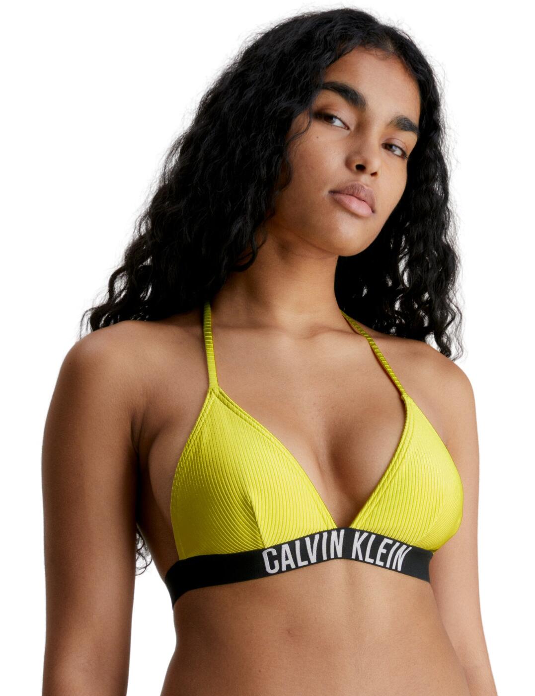 Upgrade your beach look with the Calvin Klein Intense Power triangle bikini top. Crafted with a modern and stylish design, this top has a deep V-shape and adjustable ties that offer great support and medium coverage on the bust. The ribbed fabric adds an eye-catching detail, whilst the moulded cups and removable padding provide extra shape and support. The bold elasticated underband features the iconic Calvin Klein brand logo for a signature finishing touch. The Calvin Klein Triangle Bikini Top looks perfect when worn with a pair of matching bottoms, which are also available, to create a sensational designer swimwear outfit.  Triangle bikini top Shiny ribbed material Bold Calvin Klein branded elasticated underband Wireless Triangle plunging cups Moulded cups Removable padding Clasp closure at the back Self-tie halterneck straps Matching swimwear is also available Country of origin: China Composition: 85% Recycled Nylon &pipe; 15% Elastane Listed in UK sizes  62472-107831-1429410 KW0KW01967 Plunge Bikini Top