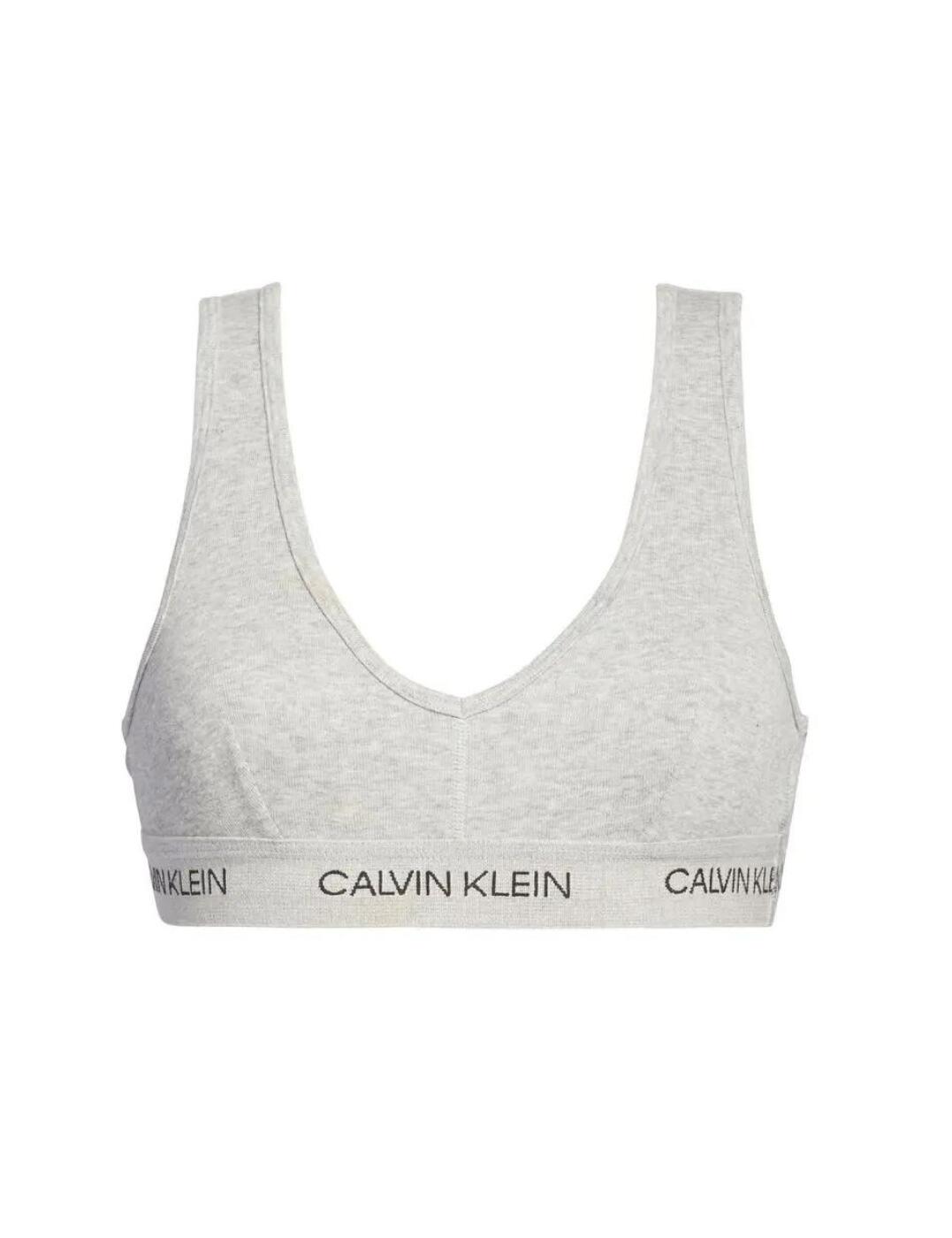 A simplistic everyday CK One bralette from Calvin Klein. Featuring a flattering scoop neckline and back; no cups or underwiring and the classic Calvin Klein printed underband for support. A bold statement patch affixed to the back provides a flash of colour. Style needn't be complicated!  Calvin Klein signature elastic underband Scoop back No cups, unlined Unwired Statement patch at the back Composition: 100% Cotton Listed in UK sizes  47280-86339 000QF5251E Bralette