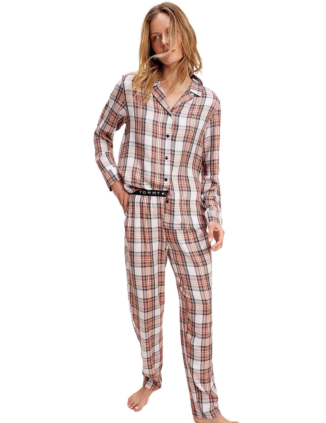 Tommy Hilfiger is iconic for its premium athleisure style and this holiday pyjama set blends this casual style with glitter and signature details creating effortlessly luxurious sleepwear. The trousers flaunt a glittery Tommy Hilfiger signature waistband and branded logo buttons across both pieces create a detailed designer look. The bold woven fabric with glitter detail, in the classic button-up design offers a modern twist on the timeless shape. A long-sleeved shirt and full-length trousers in a loose fitting design create the ultimate casual-cool style and offers the utmost comfort.  Pyjama shirt and trouser set Tommy Hilfiger branded waistband Sparkle woven detail Comfortable loose-fitting shape Full-length sleeves and trousers Composition: Top: 98% Viscose &pipe; 2% Other Composition: Bottoms: 98% Viscose &pipe; 2% Other Composition: Waistband: 69% Polyamide &pipe; 22% Polyester &pipe; 7% Elastane &pipe; 2% Other Listed in UK sizes  49247-89250 UW0UW02561  Pyjamas