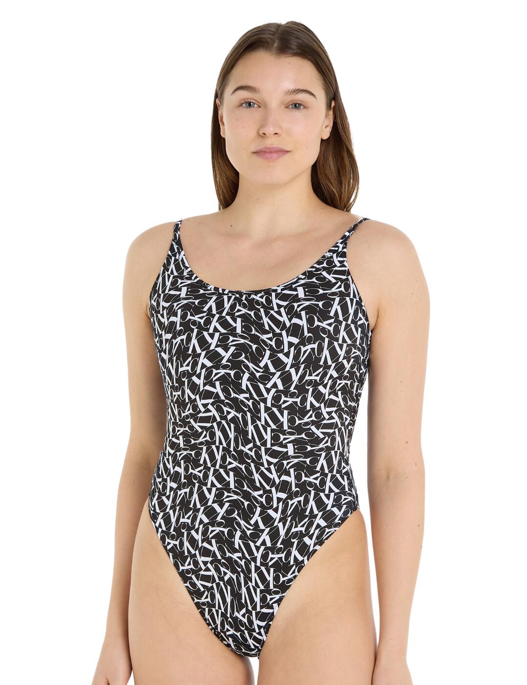 The Calvin Klein brand has a perfect staple to add to your swimwear collection now! Snap up this monogram logo one-piece swimsuit for your next getaway. This wireless and non-padded design is crafted for the utmost comfort and a simplistic look. Fixed straps and pull-on design provide ease of wear and a secure fit. A scoop neckline and back give you a flattering silhouette. This piece features cheeky rear coverage with high leg cuts for a sassy, alluring look that is sure to keep all the attention on you. The iconic monogram CK logo is printed onto this look for a distinctive and unique finish. Take a look at other matching coordinates from this brand to expand your swimwear collection further.  One piece swimsuit Non-padded Wireless Warped CK logo Fixed straps Pull-on design Cheeky rear coverage High leg cuts Matching coordinates available Country of origin: Vietnam Composition: 83% Recycled Nylon &pipe; 17% Elastane Listed in UK sizes  59726-104486-1388857 KW0KW02086 Swimsuit