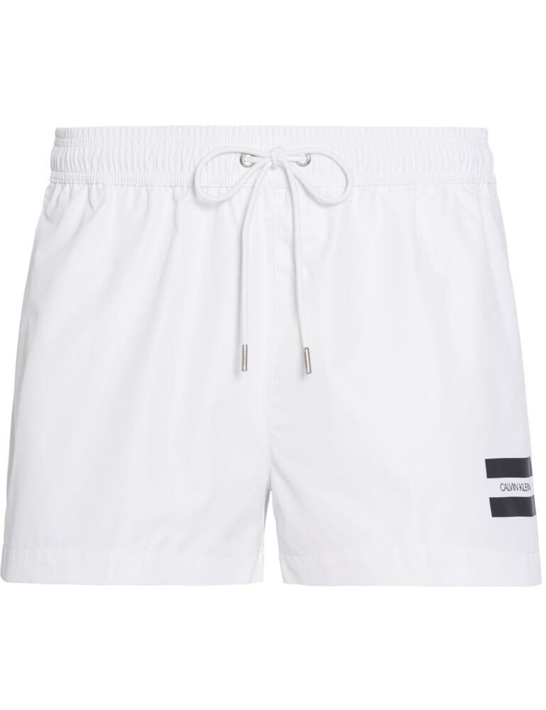 These drawstring trunks from Calvin Klein's swimwear are a true statement piece. Ensuring a perfect fit with the signature elasticated waistband and drawstrings. Velcro pockets on the back allow you to store things with the security of not losing them. Finished off with the Calvin Klein logo at the left leg for a stylish look.  Signature elasticated waistband Drawstrings Velcro pockets on the back Mesh lining Calvin Klein logo on the leg Composition: 100% Recycled Polyester Listed in UK sizes  50162-90754 KM0KM00441 Men's Swim Trunks