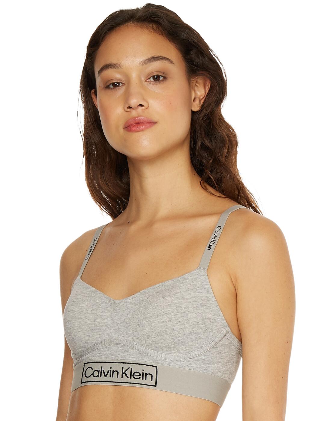 The Reimagined Heritage range by Calvin Klein introduces everyday lingerie with simple designs and classic Calvin Klein branding. This lightly lined bralette features a plain opaque design with the iconic elastic Calvin Klein under band. The lightly lined cups create a flattering fit and the cup shape makes a feminine feel. It has adjustable straps which can be worn as a cross back and they have the Calvin Klein branding along them. The bra fastens with a hook and eye closure at the rear.