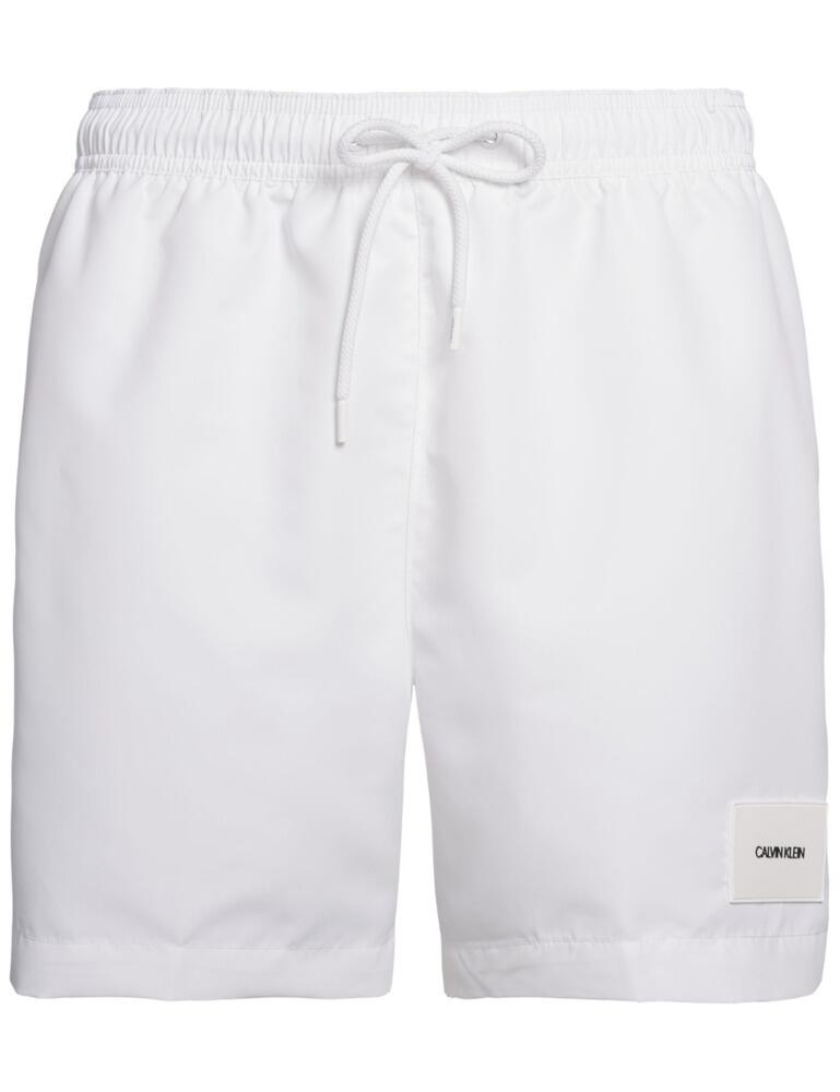 These Calvin Klein drawstring trunks are sure to be your best swimwear item. With side pockets that are in line with the seams creating an almost invisible look, ensuring your valuables are safe. The elasticated waist and drawstring ensure you find your perfect fit and guarantee no movement. A mid-length cut offers a stylish look finished off with the Calvin Klein logo on the bottom of the left leg.  Side pockets Elasticated waist Drawstrings Mid-length Branded patch Composition: 100% Polyester Listed in UK sizes  50212-90840 KM0KM00296 Men's Swim Trunks