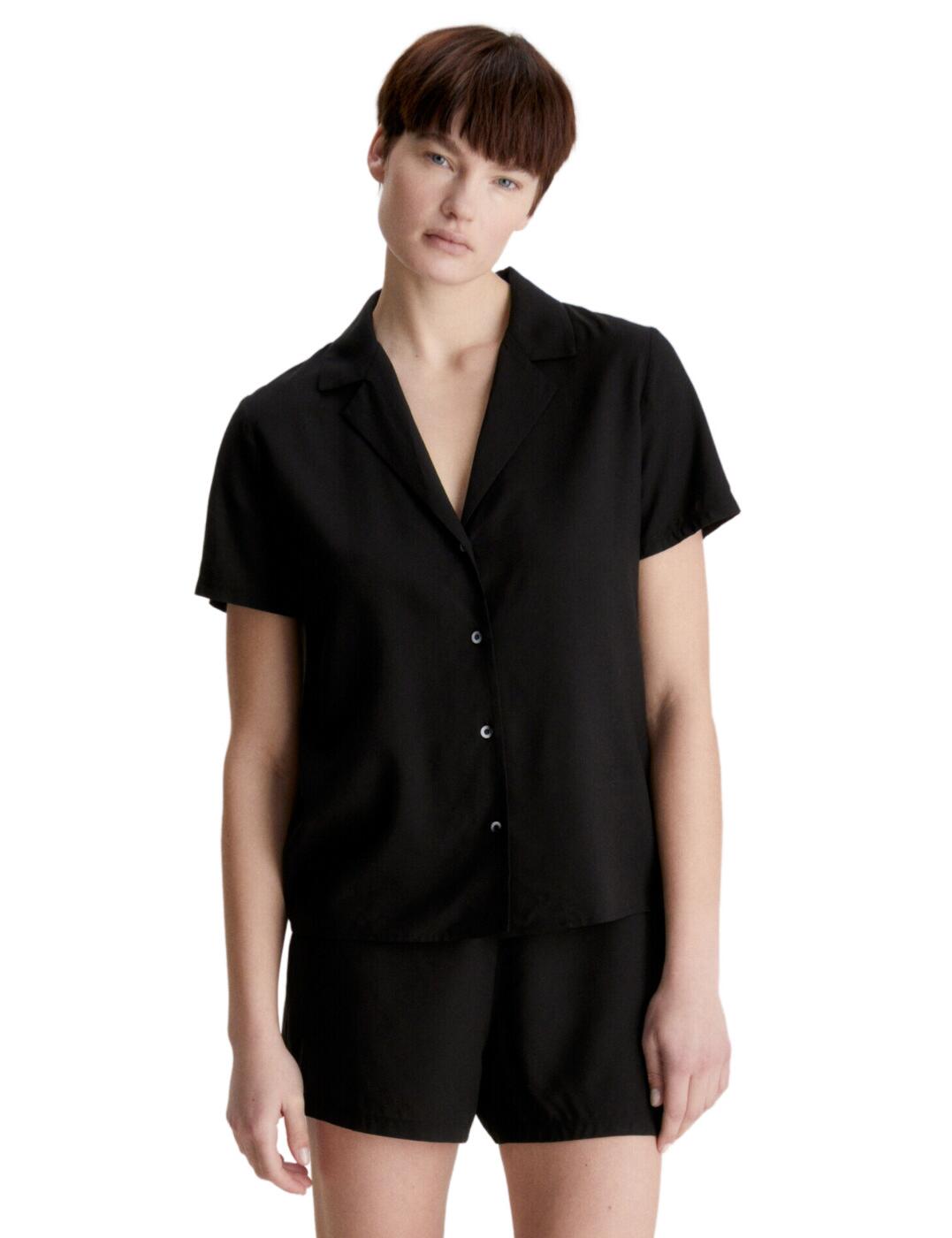 Sleep in style and comfort in the Calvin Klein short set. This timeless pyjama set is perfect for the woman who wants to look and feel great while relaxing at home. Featuring a shirt top with a V neckline and button-down front, as well as short sleeves, this PJ set provides both comfort and style. The mini shorts have an elasticated waistband for a perfect fit. With its elegant plain design, this set will have you looking chic while enjoying a well-deserved rest. The fabric is soft and comfortable against the skin, giving you total peace of mind throughout the night. Take your downtime to the next level with the Calvin Klein short set.