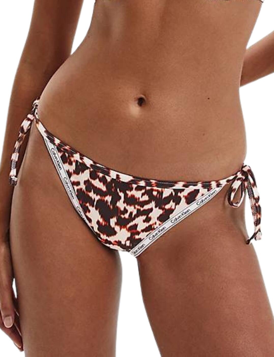 Get wild with the new Logo Tape collection from Calvin Klein. This tie side bikini brief brings refined classic cuts from a fresh perspective. Boasts gorgeous slim elastic trims with the iconic Calvin Klein logo for a fun graphic look. Designed with self-tie hip straps which allow for a fit tailored entirely to your own preference to perfectly showcase your silhouette. Fully lined for coverage and is cut to a mid-rise waist with medium rear coverage, perfect for those who want to feel sexy whilst maintaining some modesty.  Made with 79% sustainably sourced fabric Fully lined Mid-rise waist Medium rear coverage Self-tie straps at the hip Country of origin: Sri Lanka Composition: 79% Recycled Polyester &pipe; 21% Elastane Listed in UK sizes  54990-98060-1279786 KW0KW01862  Side Tie Bikini Briefs